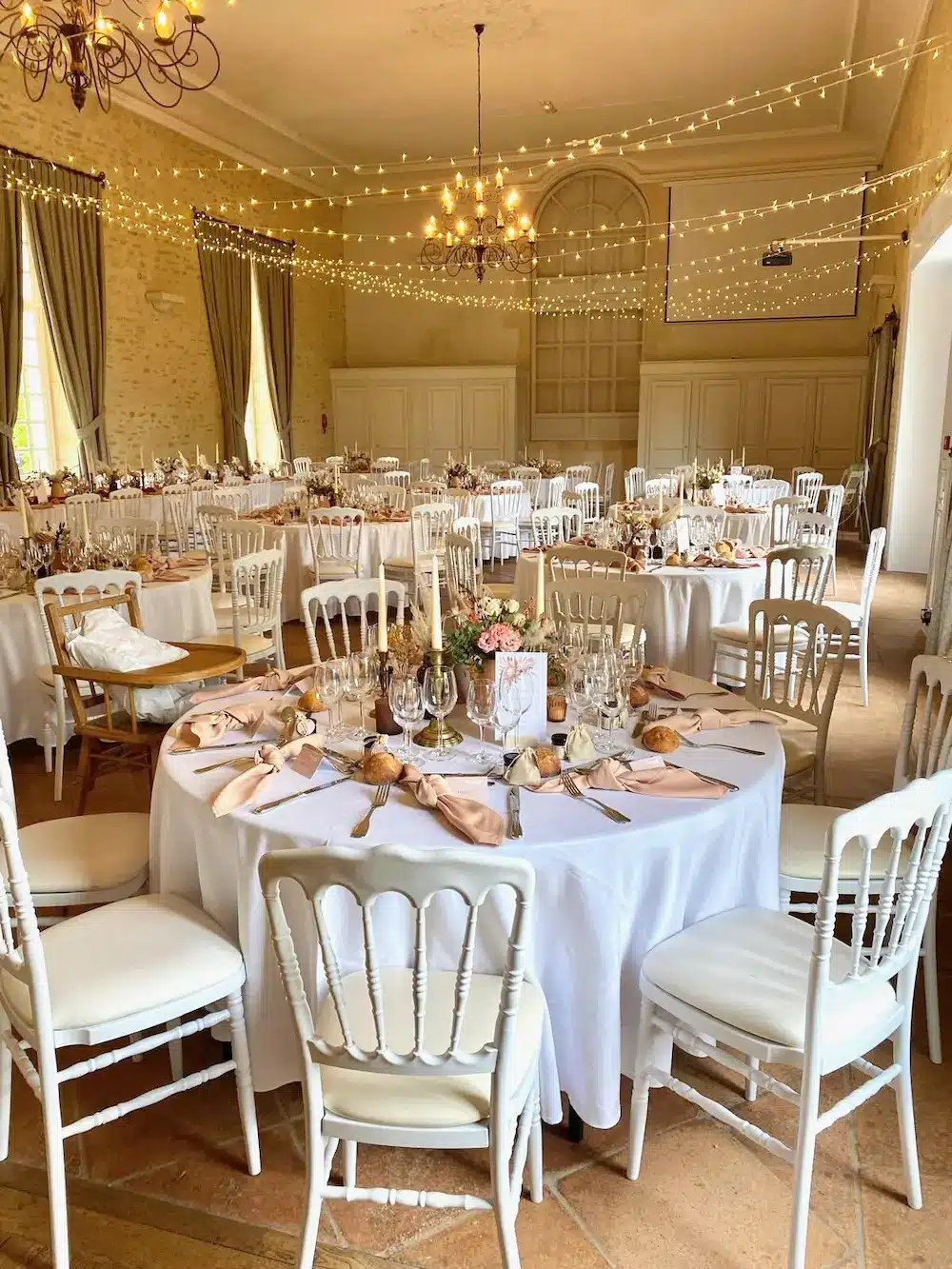 Photo d'une salle de réception avec des tables dressées pour un mariage par Menard Traiteur Caen